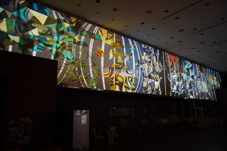 一旗プロデュース「とよたまちなか芸術祭 豊田市民文化会館大壁画プロジェクションマッピング」の公式記録動画を公開。横28m×縦4mの綴錦織の大壁画に幻想的なプロジェクションマッピング。のメイン画像