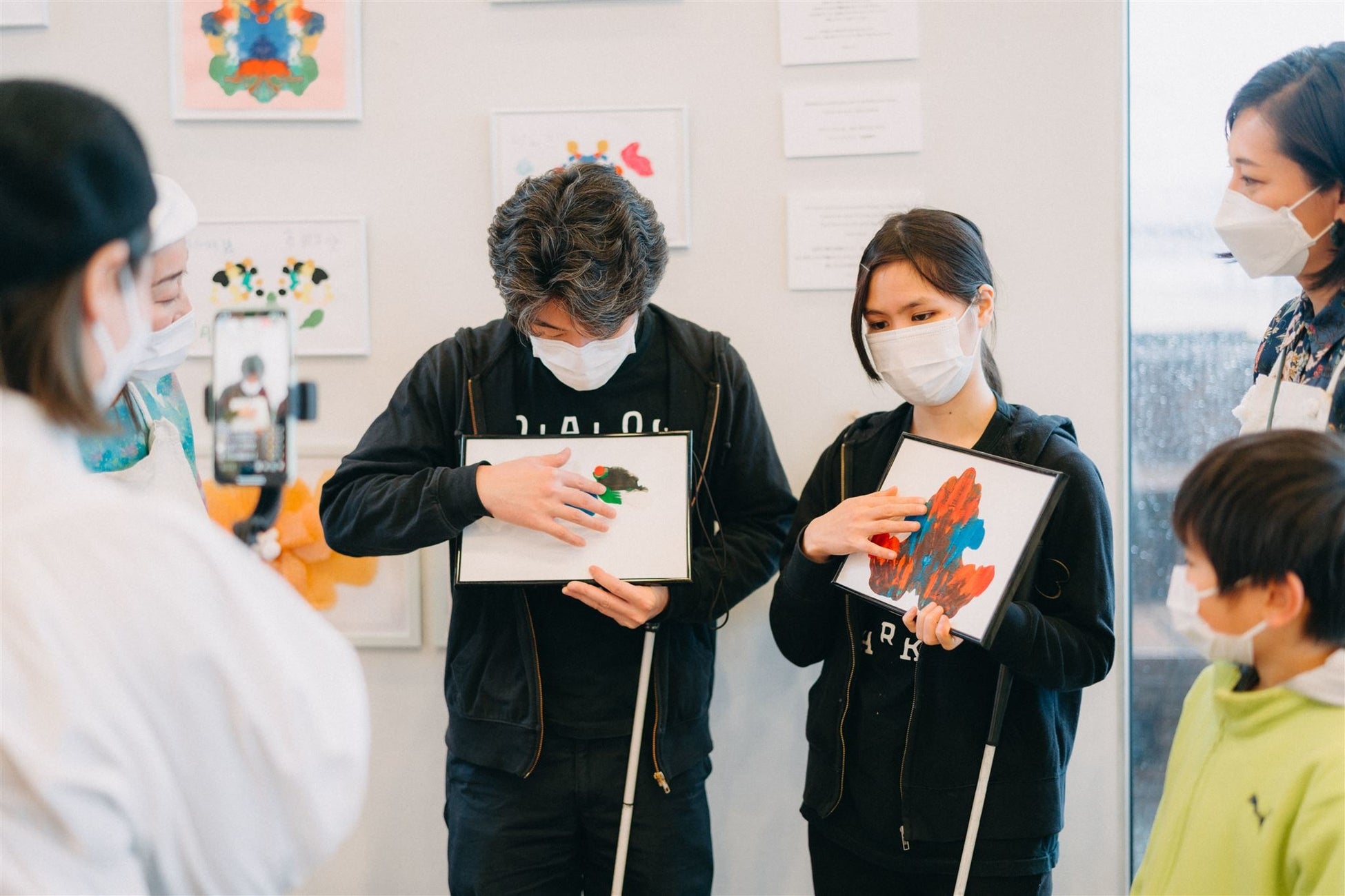 「やさしさとは？」を問いかける「ダイバーシティアート やさしさの花展」のサブ画像3_（ダイアログ・イン・ザ・ダークのアテンドのお二人（視覚障害者）とアート鑑賞をしている様子）