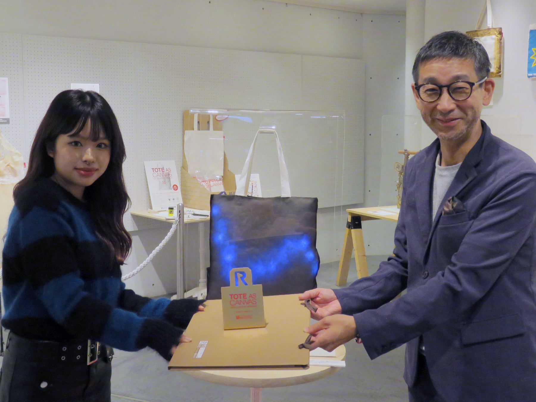 一般公募によるアートなトートバッグ作品のコンテスト！本年度受賞作品展、10/25まで開催中。「第19回 トート・アズ・キャンバス アート&デザインアワード by ROOTOTE」プレビューレポートのサブ画像6_本年度グランプリ「雷雲」作者の山田莉音夢さんを表彰。 左 山田莉音夢さん、右 株式会社ルートート 代表取締役 神谷富士雄