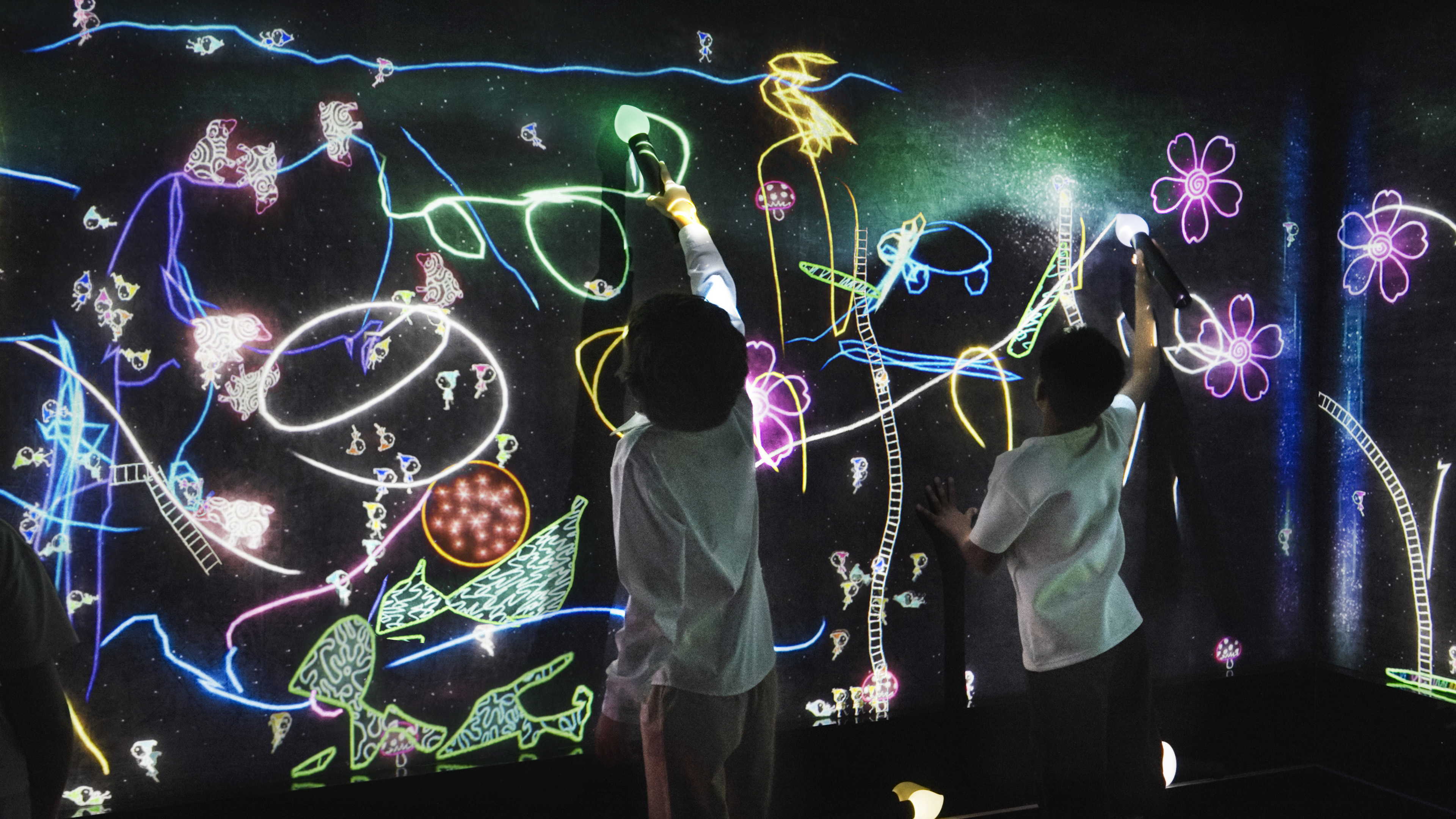 チームラボ、シンガポールの常設展「teamLab Future World」で、新たに3作品を公開。既存作品も複数リニューアル。のサブ画像3_周りの人と一緒に大きな絵を描き、たくさんのスタンプを押して、こびとたちの世界に新たな世界を描いて様々な力を与えると、こびとたちはより果敢に遊びはじめる。チームラボ《こびとが住まう宇宙の窓》© チームラボ